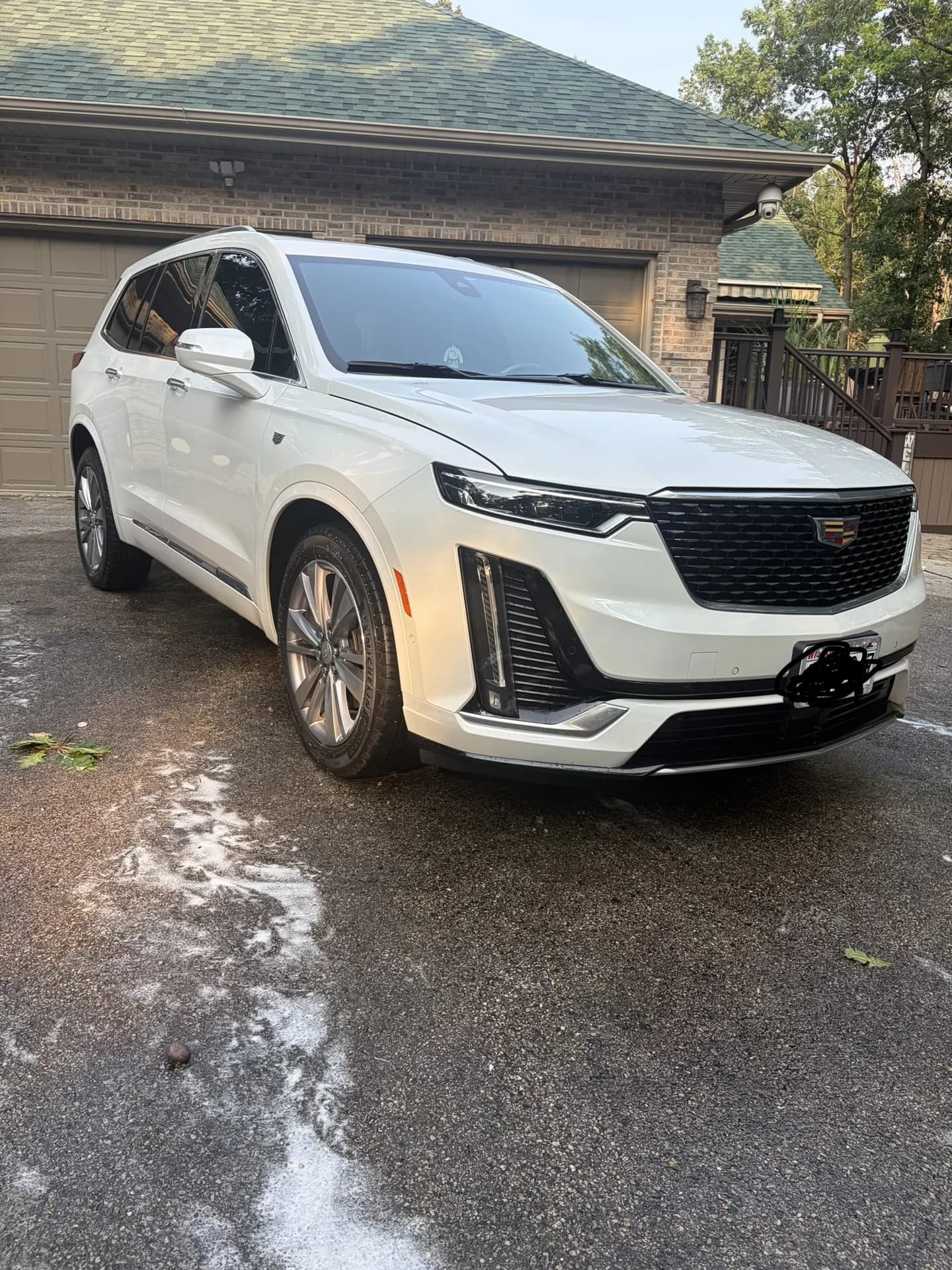 White Cadillac SUV freshly washed in a driveway